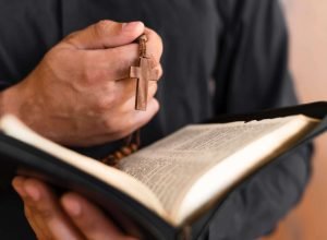 person-holding-holy-book-rosary