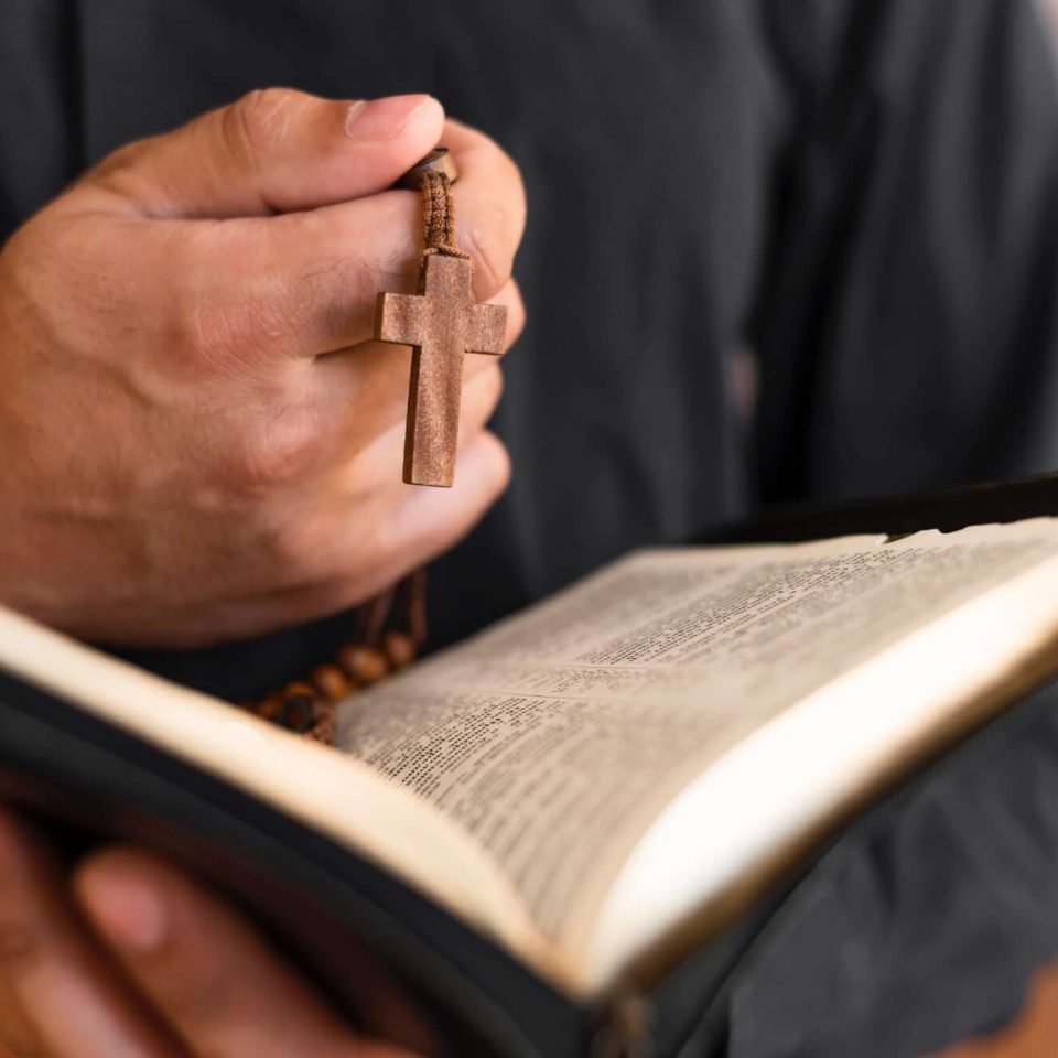 person-holding-holy-book-rosary